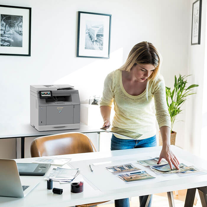 woman in office arranging photos on desk