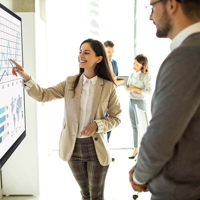 woman pointing at interactive display in office
