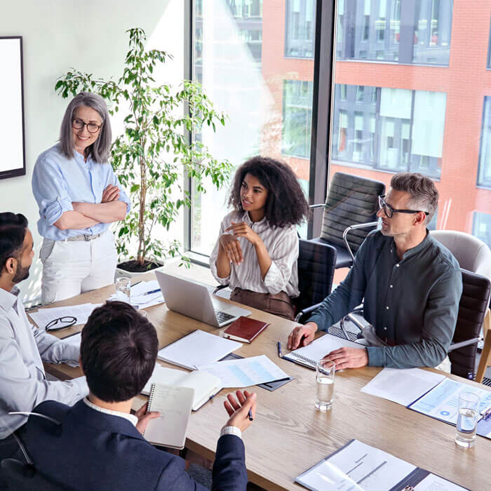 workers seated around table for corporate meeting