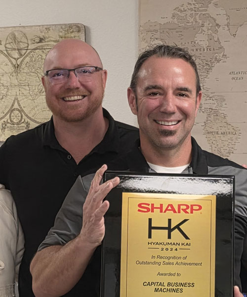 Casey and Derek holding award